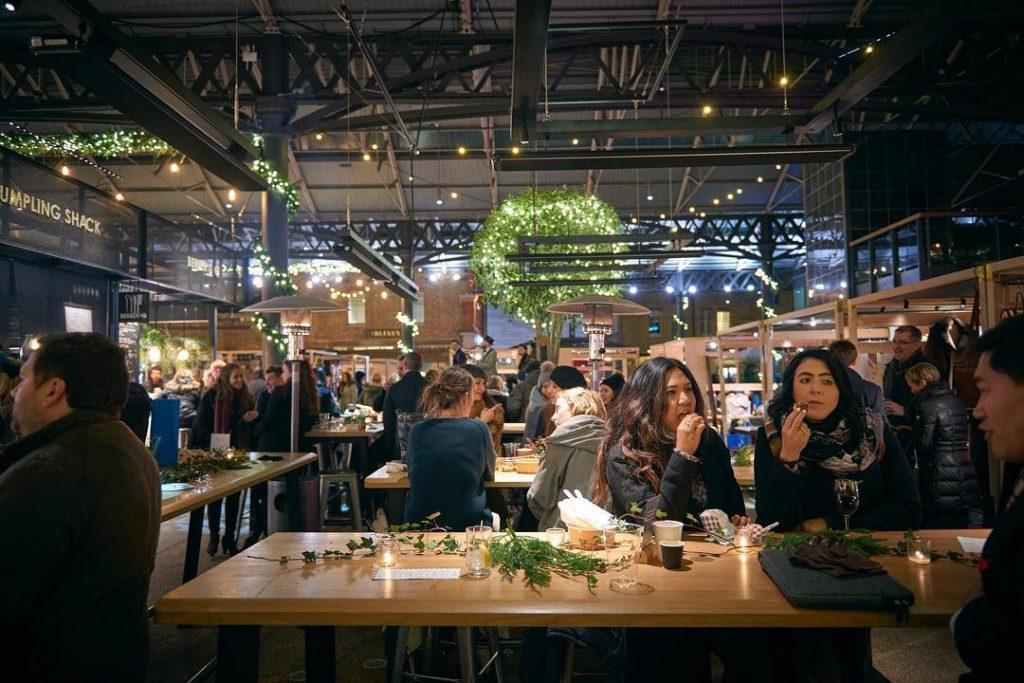 People shopping and enjoying their time at the Old Spitalfields Market in London, England 