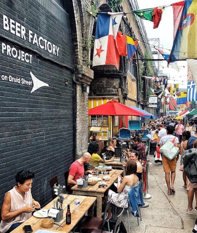 People enjoying food at Maltby Street Market in South East London