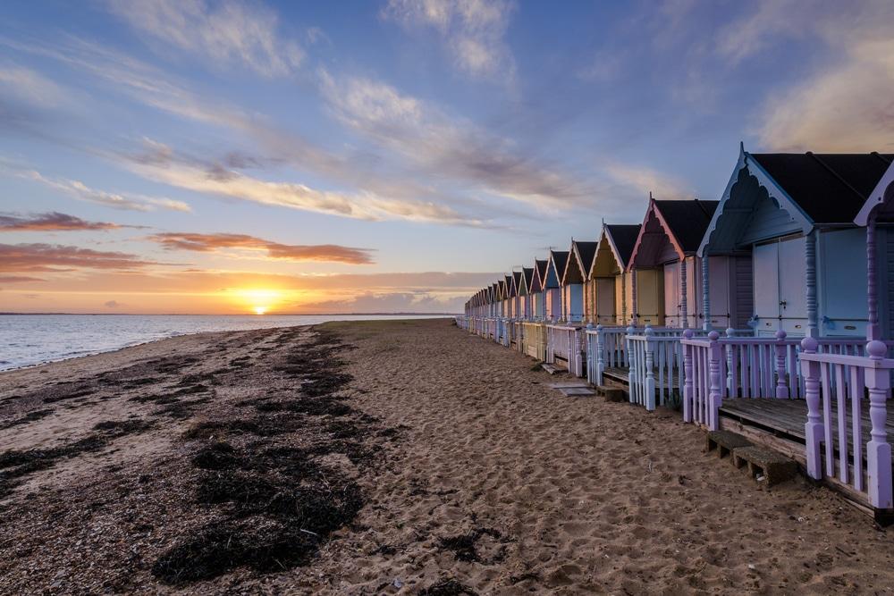 The gorgeous beach huts as the sun sets at Mersea, one of the best seaside towns near London